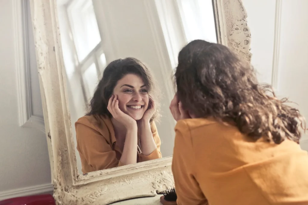 woman looking in the mirror after chemical peel procedure
